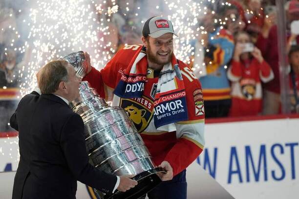 Aleksander Barkov přebírá Stanley Cup pro vítěze play off NHL 2024.